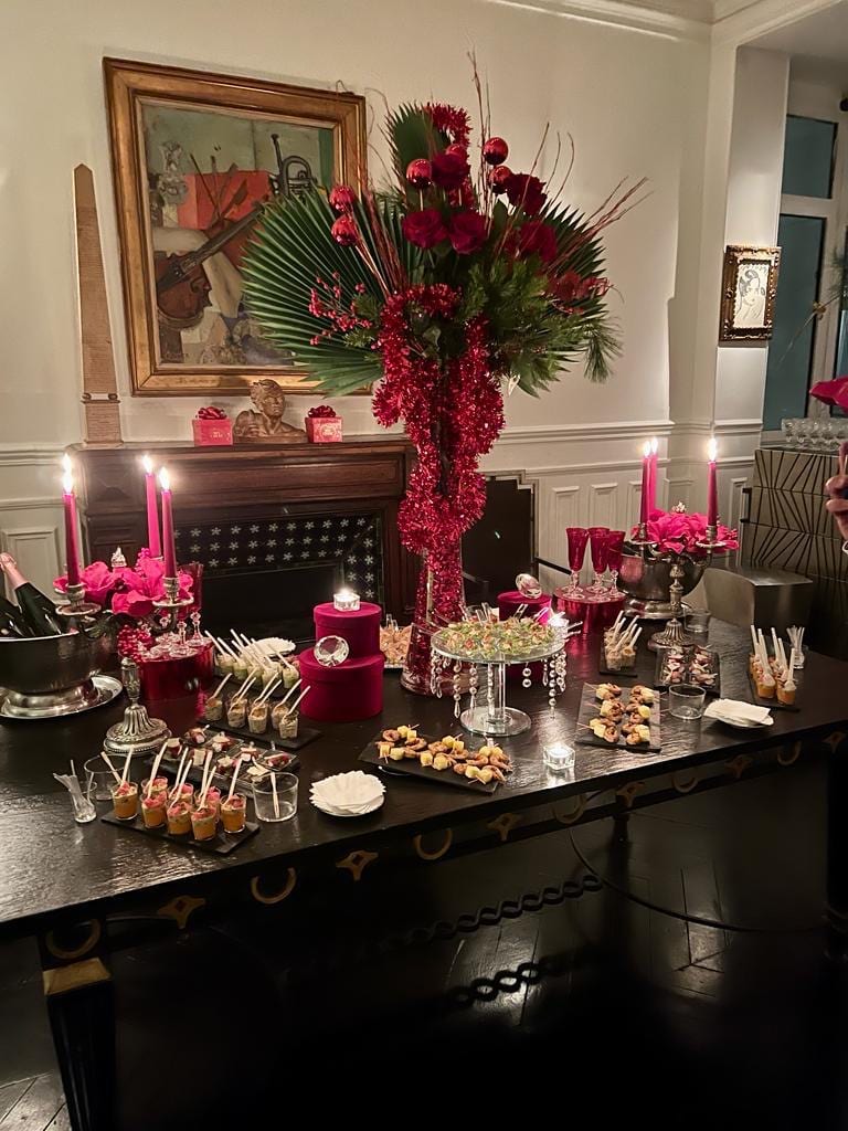 Buffet festif aux tons rouges avec verrines, mignardises et bougies pourpres