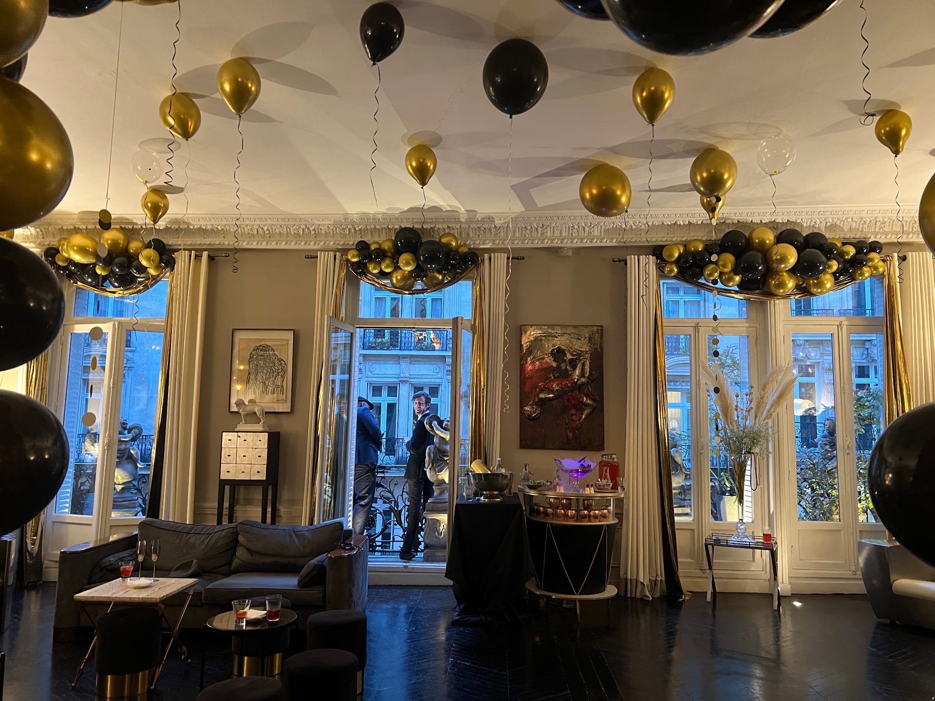 Salon haussmannien décoré de ballons or et noirs pour anniversaire