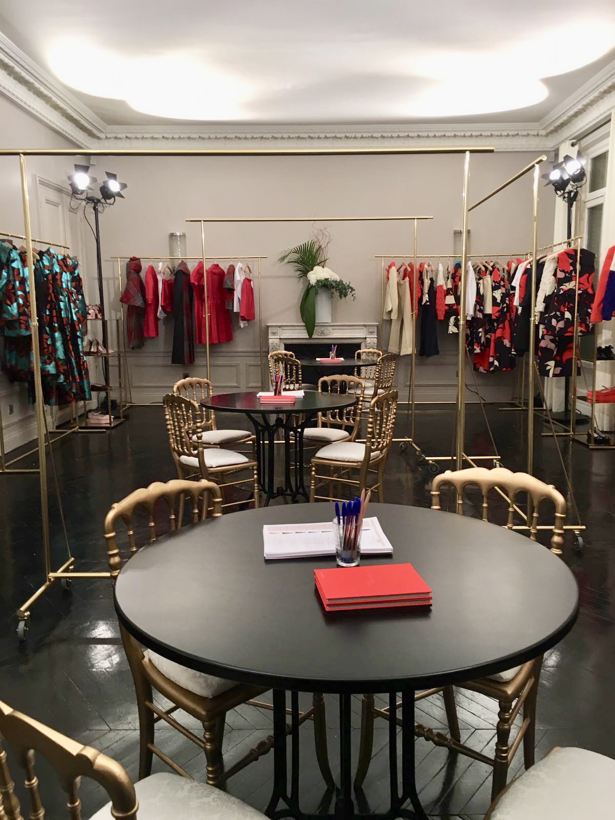 Fashion Week — showroom robes rouges et chaises dorées