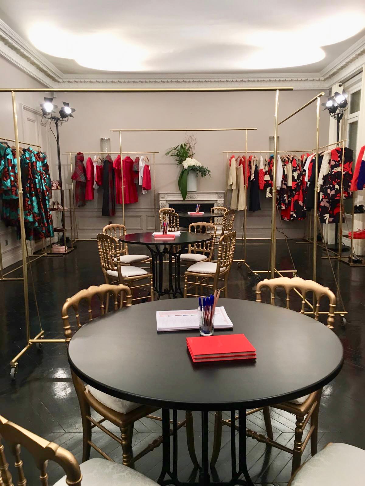 Fashion Week — showroom robes rouges et chaises dorées