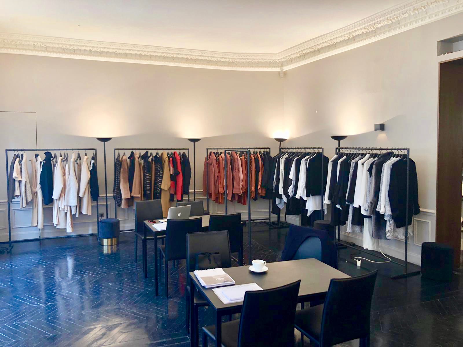 Fashion Week — salle d'enfilade avec portants et collection mode