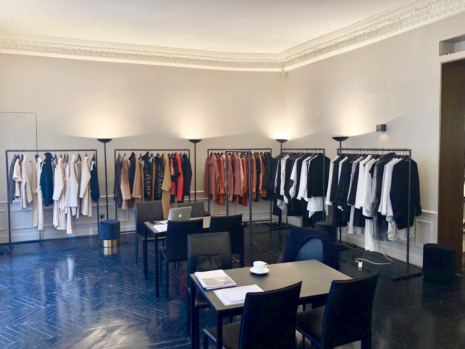 Fashion Week — salle d'enfilade avec portants et collection mode