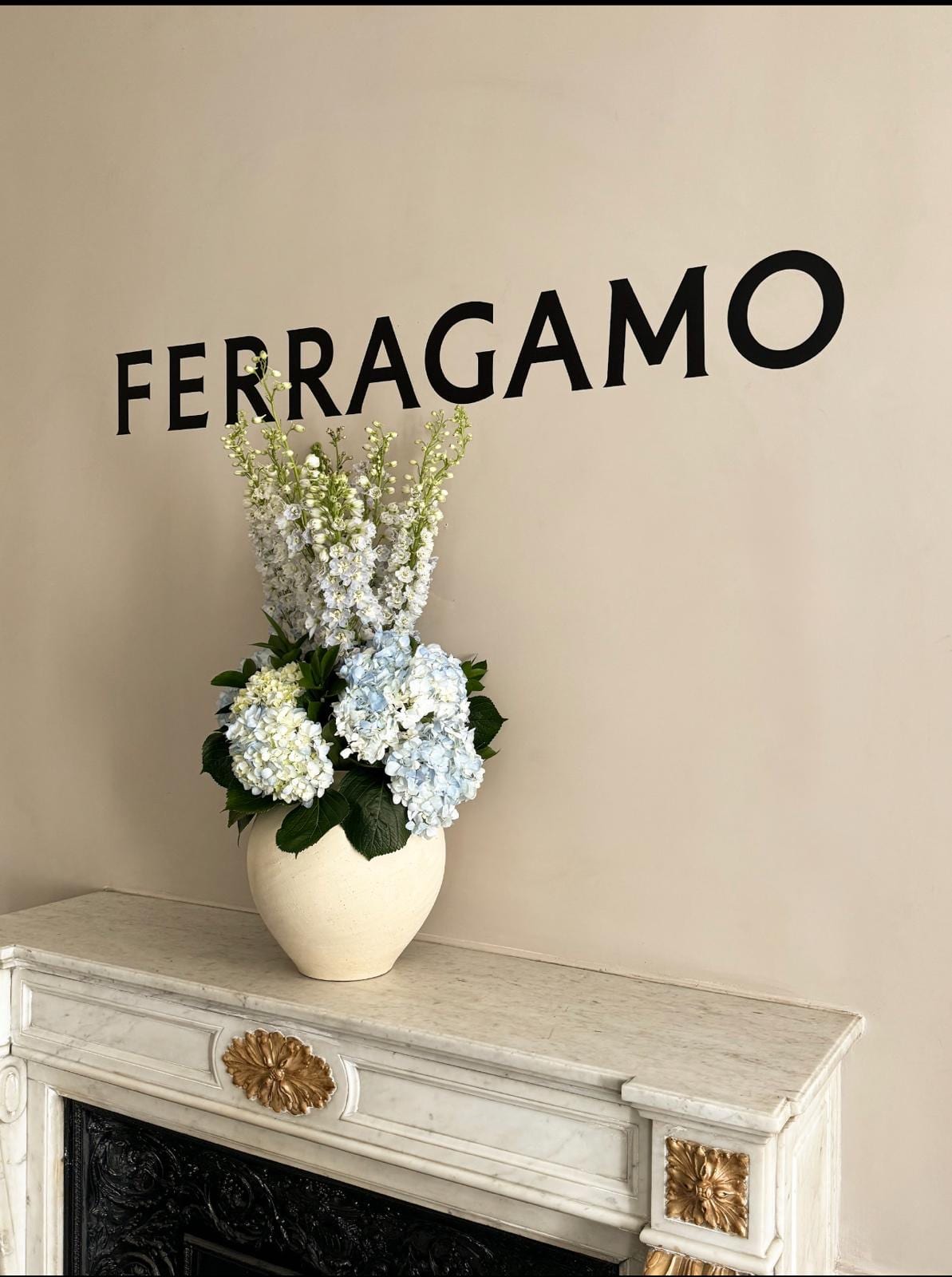 Ferragamo — logo et composition florale sur cheminée en marbre
