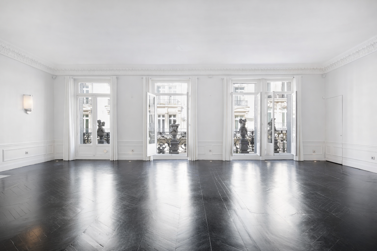 Le grand salon vide du Loft Triangle d'Or, balcons filants et lumière naturelle