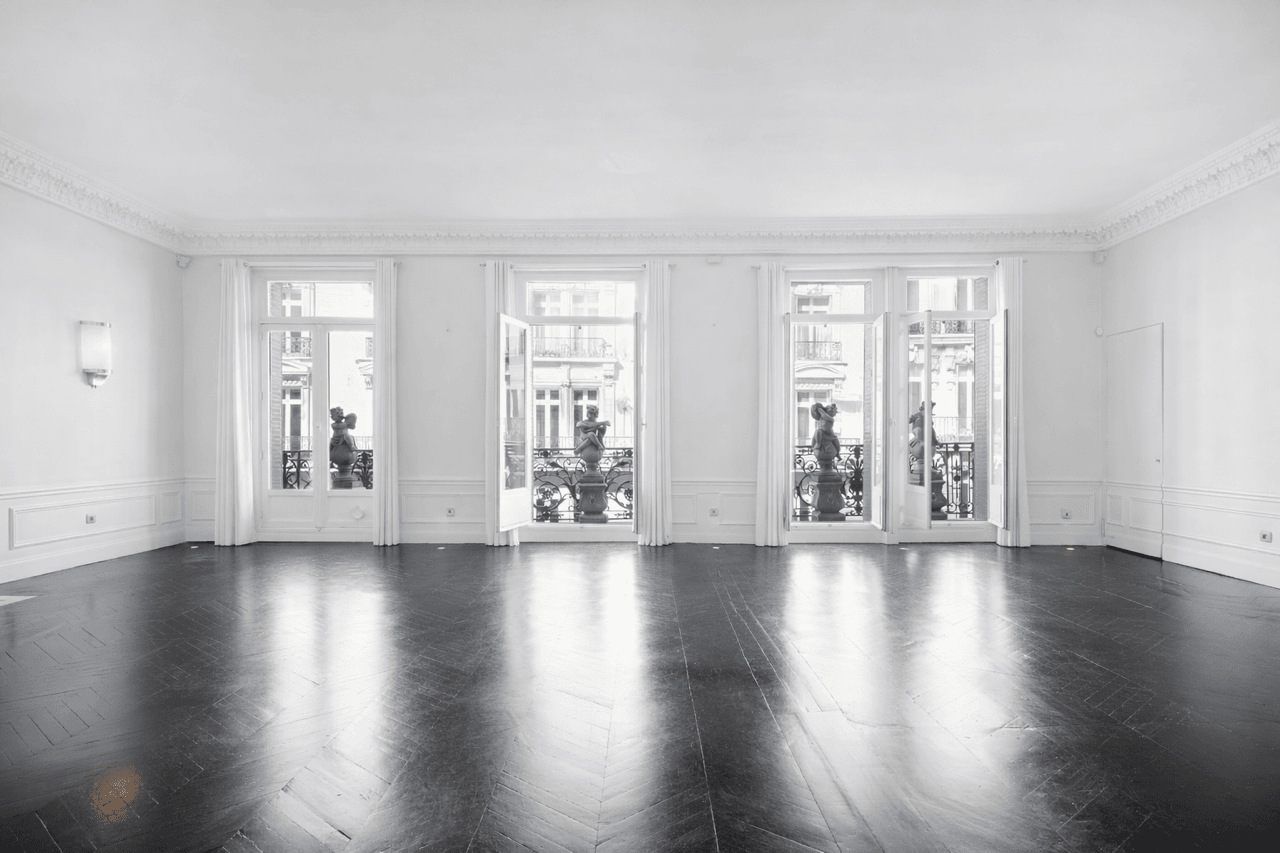 Le grand salon vide du Loft Triangle d'Or, balcons filants et lumière naturelle