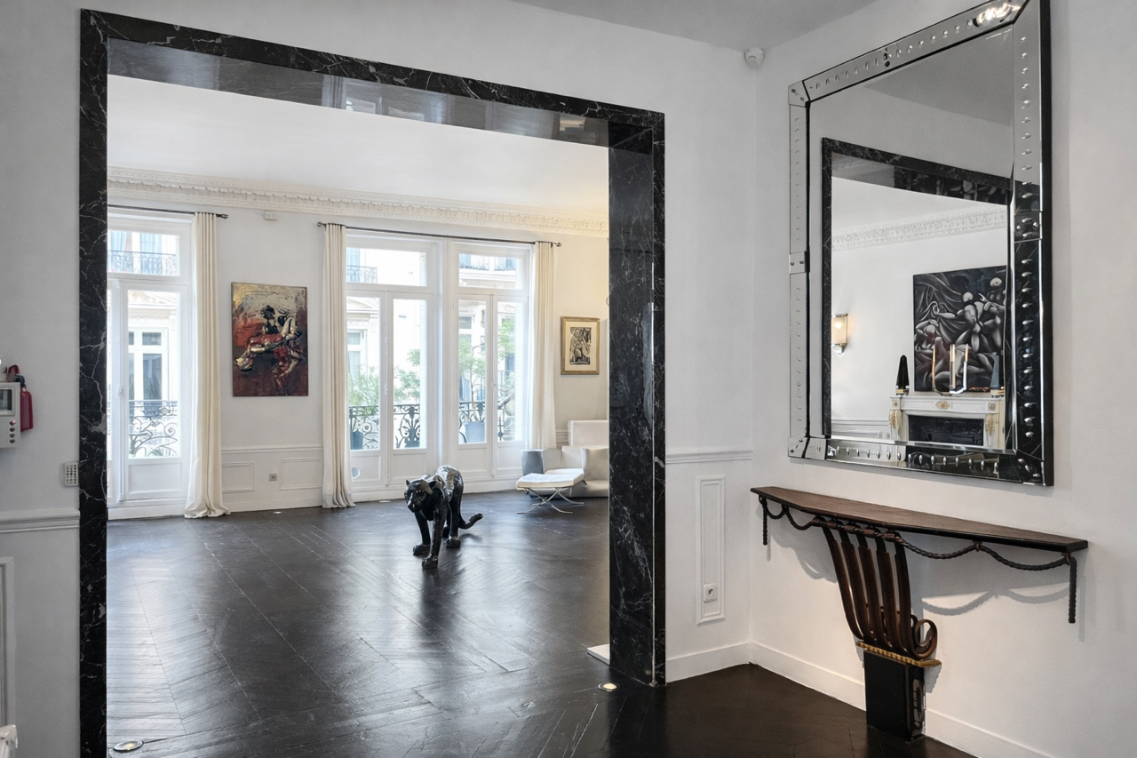 Vestibule en marbre noir, miroir d'apparat et console — le seuil du Loft Triangle d'Or