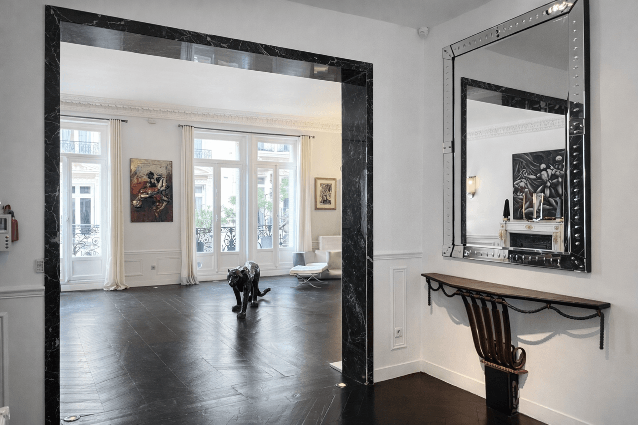 Vestibule en marbre noir, miroir d'apparat et console — le seuil du Loft Triangle d'Or