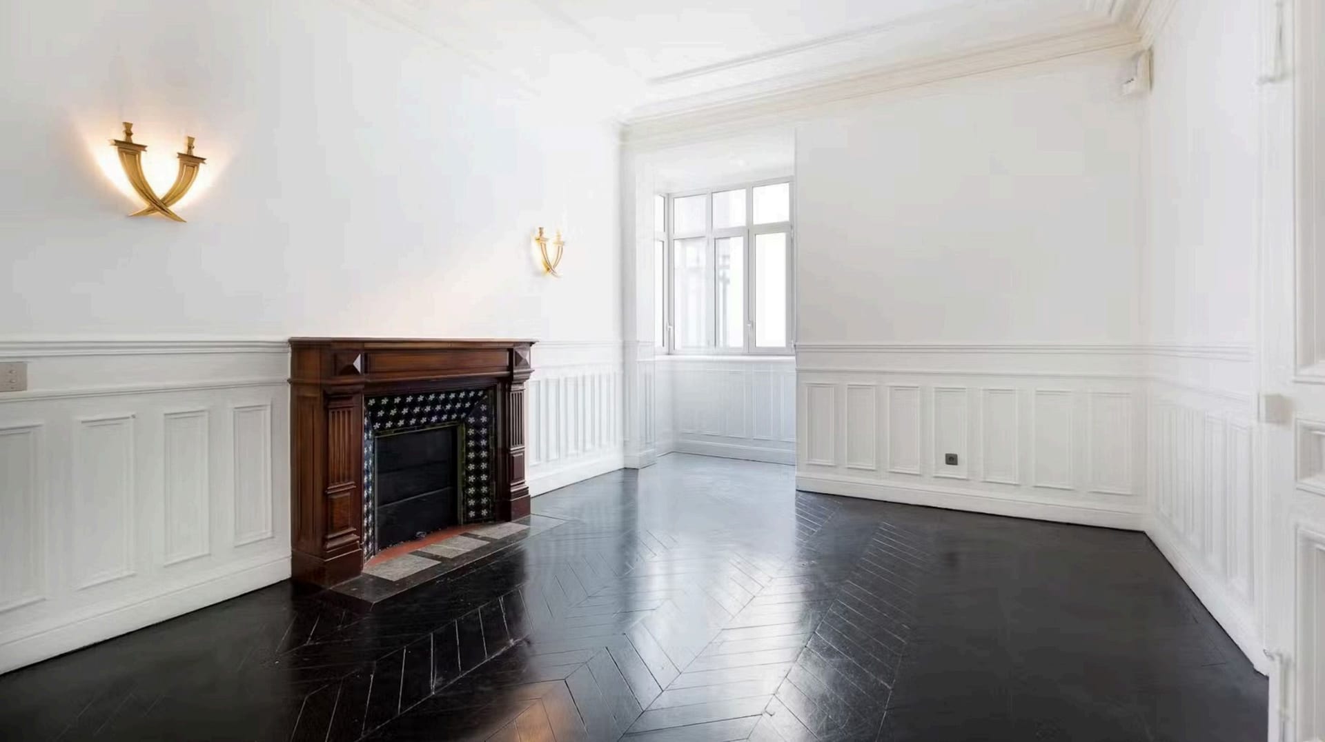 Couloir de réception, appliques murales et parquet chevron noir